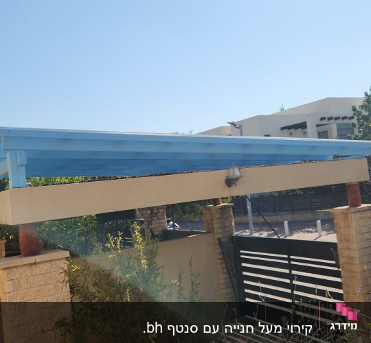 פרגולה מעץ צבועה בכחול עם עמודי אבן